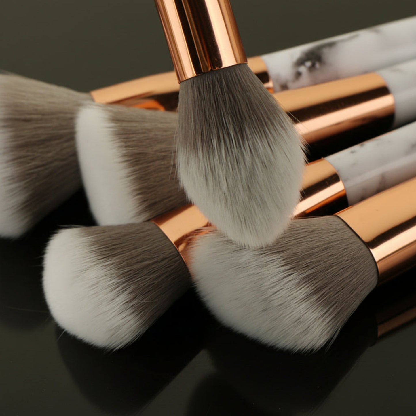 Makeup brushes with rose gold handles on a dark background