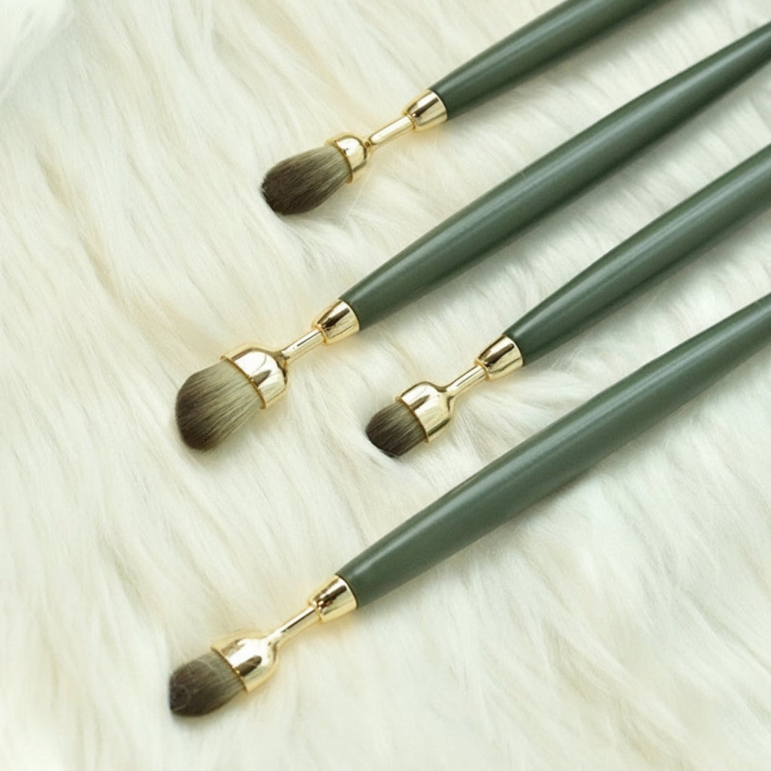 Set of makeup brushes with green handles and gold accents on a textured white surface, featuring the brand 'LOFREE'.